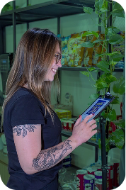 Empreendedora utilizando o catálogo digital do Conecta Venda em um tablet dentro do seu espaço de trabalho, demonstrando praticidade na gestão de produtos.